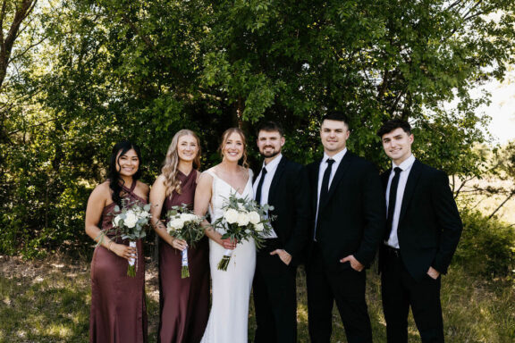 Wedding party in front of trees.