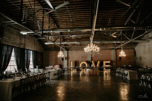 Interior or Brick & Mortar venue. There are brick walls, polished concrete floors and a lareg, lighted LOVE sign.