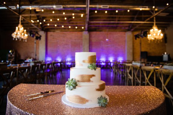 Wedding cake in nicely lit reception hall