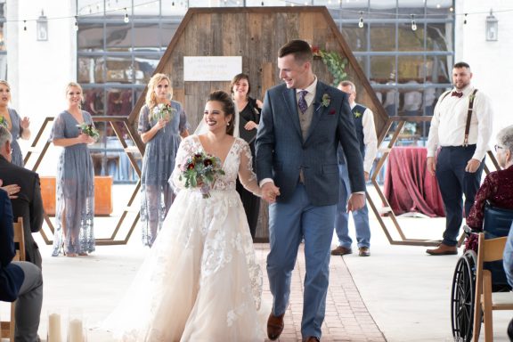 Bride and groom walking down aisle of outdoor venue