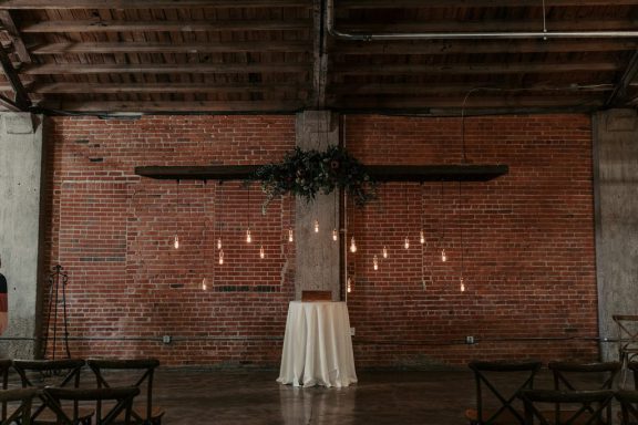 Urban backdrop for a wedding with brick wall and hanging ligths